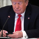 A photo of Donald Trump on his phone, perhaps sending an email